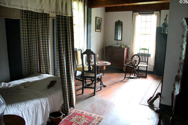 Canopy bed, table, chairs, chest & spinning wheel in Schenck House bedroom at Old Bethpage Village. Old Bethpage, NY.
