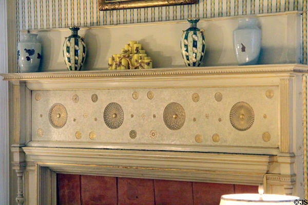 Fireplace with surround decorated with circles in relief at Kingscote. Newport, RI.