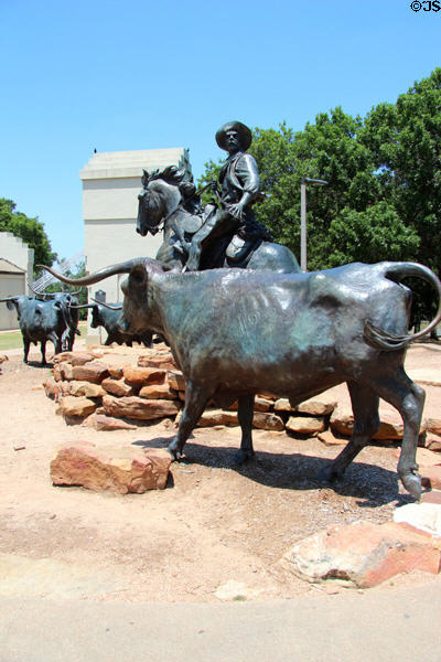 Sculpted trail boss drives longhorns onto Waco Suspension Bridge to cross Brazos on Chisholm Trail. Waco, TX.