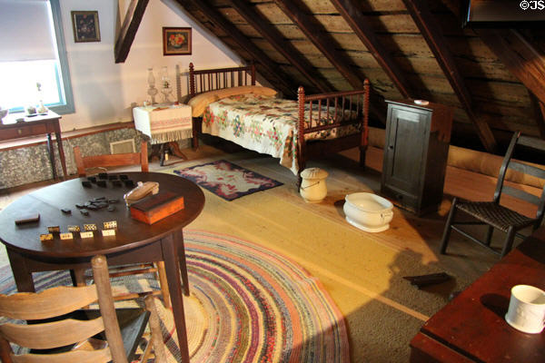 Spool bed & round four-legged table in attic at Museum of Texas Handmade Furniture. New Braunfels, TX.