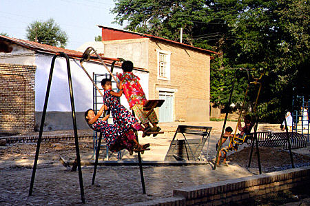 Children play on swing in Samarkand. Uzbekistan.