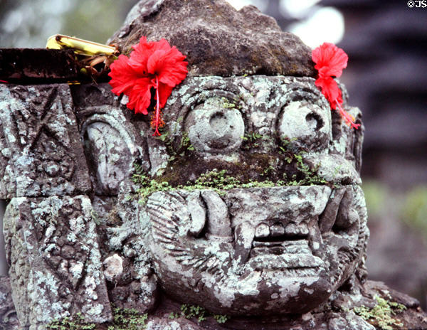 Carving of head decked with flowers. Bali, Indonesia.