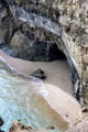 Water rushes towards a cave at base of cliffs in Port Campbell National Park. Australia