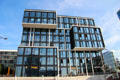 Front facade with shops of three level black glass building in HafenCity. Hamburg, Germany.