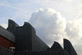 Distinctive roof line against cumulus clouds at Ludwig Museum. Köln, Germany.