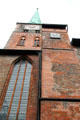 Side view of clock tower with sundial at St Jacob's Church. Lübeck, Germany.