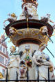 St Peter's Fountain detail with statues representing cardinal virtues of courage & temperance under geese & putti riding dolphins in Hauptmarkt. Trier, Germany.