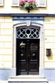 Doorway with flowers and ornate fixtures. Zons, Germany.