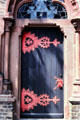 Church door with ornate pink hinges & stained glass fan window. Zons, Germany.