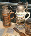 Beer steins of three railway army reserve regiments topped by model locomotives at Nuremberg Transport Museum. Nuremberg, Germany.
