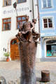 Brotbrunnen fountain with figures of bakery workers & wheat sheaves carved on pedestal on Schrannengasse in town center. Füssen, Germany.