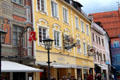 Buildings with ornate metal signs along Reichenstrasse pedestrian area. Füssen, Germany.