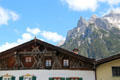 Elaborate woodwork on gable of building with Alps foothills in background. Mittenwald, Germany.