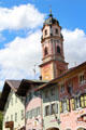 Church of Sts Peter & Paul tower above painted buildings. Mittenwald, Germany.