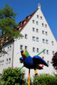 Colorful sparrow sculpture carrying a long straw, named "Pipe Sparrow", emblem of City of Ulm, outside Museum of Bread and Art. Ulm, Germany.