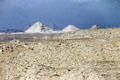 Six Pyramids including Cheops, Chephren & Mycerinus seen across rocky desert from Saqqara. Giza, Egypt.