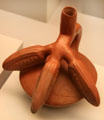 Chimu culture ceramic stirrup-spout bottle with pacae Andean fruit from Peru at Museum of America. Madrid, Spain.