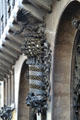 Decoration of bird atop crown atop spiral pole between entrance doors at Palau Güell. Barcelona, Spain.