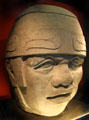 Copy of Olmec head from Mexico in window of Barbier Mueller Precolumbian Art Museum. Barcelona, Spain
