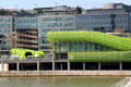 Buildings along Quai d'Austerlitz with green tubing facade on River Seine. Paris, France.