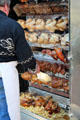Shop with racks of roasted chickens & meats. Paris, France.
