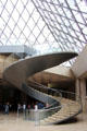 Spiral staircase which leads from pyramid entrance to lower floor at Louvre Museum. Paris, France.