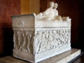 Marble sarcophagus with portrait carving of a couple on lid & scene of battle of Greeks & Amazons on front found in Thessaloniki at Louvre Museum. Paris, France.