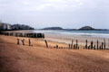Empty beach with anti-erosion fences & islands in distance. St Malo, France.