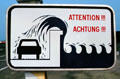 Sign warning of dangers of parking beside sea wall. St Malo, France