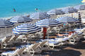 Striped umbrellas on beach along Promenade des Anglais. Nice, France