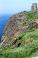 Four story tower on top shows scale of cliffs of Moher. Ireland.