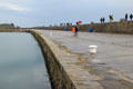 Walking along Howth harbor breakwater. Howth, Ireland.