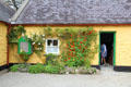 Entrance with climbing roses & nasturtiums at Quille's farm at Muckross Traditional Farms in Killarney National Park. Killarney, Ireland