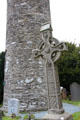 Celtic cross at base of round tower at Glendalough. Ireland.