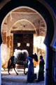 Street scene with donkey under arches. Fes, Morocco