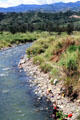 Families wash clothes by the river between Kundiawa and Minj with typical highland landscape in background. Papua New Guinea.