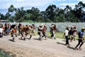 Armed with spears villagers run down road to combat. Papua New Guinea.