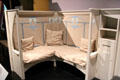 White painted settle with reproduction cushions & hanging by Charles Rennie Mackintosh at National Museum of Scotland. Edinburgh, Scotland.