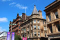Renaissance-style commercial sandstone building with octagonal corner with red sandstone St Vincent Chambers beyond. Glasgow, Scotland.
