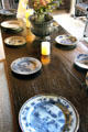 Dining table laid with ceramic plates in High Hall at Culross Palace. Culross, Scotland.
