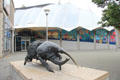Bristol Aquarium & giant botanical house with bronze sculpture of Rhinoceros beetle by Nicola Hicks. Bristol, England.