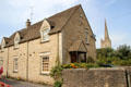 Typical heritage home with church spire in distance. Burford, England.