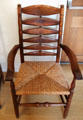 Turned arm chair in yew wood with rush seating & bog oak bobbins designed by Gordon Russell at Gordon Russell Design Museum. Broadway, England.