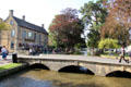 Stone footbridge crossing River Windrush in town center. Bourton-on-the-Water, England