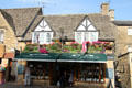 Shop on main street adorned with roof garden and British flags. Bourton-on-the-Water, England.