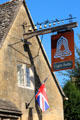 Eight bells pub sign surmounted by eight bells. Chipping Campden, England.