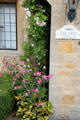 The Grey Cottage with climbing flowering vine. Lower Slaughter, England.