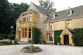Cotswold stone residence with slate roof pierced by dormer windows. Upper Slaughter, England