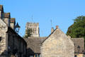 Roofs on vintage buildings with tower of Church of St Peter & St Paul in background. Northleach, England.