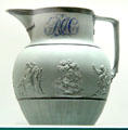 Green stoneware jug with mythological reliefs & painted initials from Staffordshire at Potteries Museum & Art Gallery. Hanley, Stoke-on-Trent, England.
